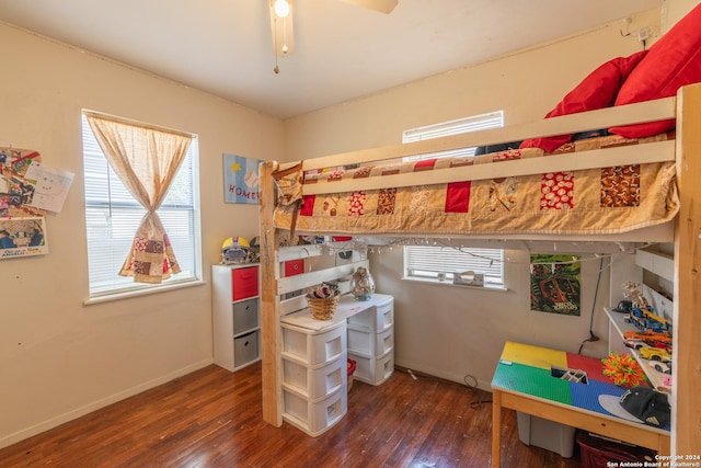 bedroom with wood-type flooring, multiple windows, and baseboards