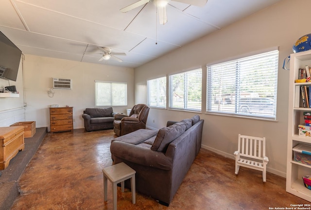 living area featuring a ceiling fan, finished concrete flooring, baseboards, and an AC wall unit