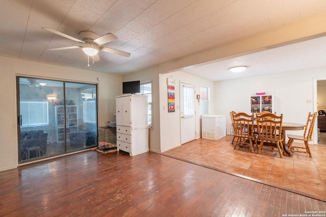 dining space with a ceiling fan, wood finished floors, and baseboards