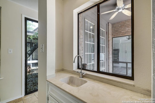 bar with a sink, a ceiling fan, and light tile patterned flooring
