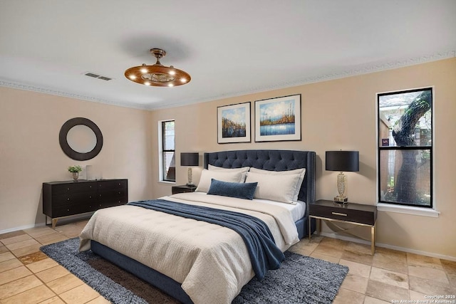 bedroom with light tile patterned floors, baseboards, and ornamental molding