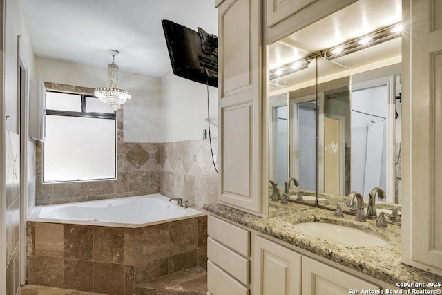 full bathroom featuring a bath, vanity, and a chandelier