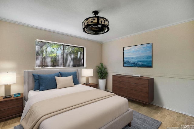 bedroom with light wood finished floors and crown molding