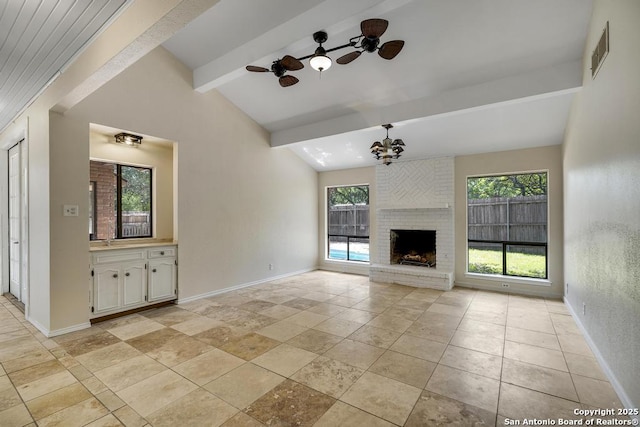 unfurnished living room with a ceiling fan, a sink, baseboards, and a chandelier