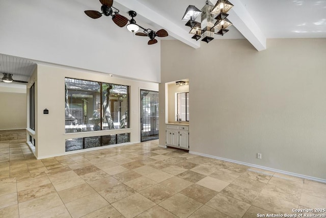 unfurnished room with ceiling fan, beam ceiling, a chandelier, baseboards, and light stone finish flooring