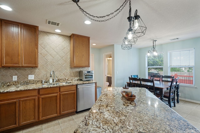 3738 Sumantra, San Antonio, TX 78261 - kitchen with dishwasher, a sink, brown cabinets, light tile patterned floors, and decorative backsplash