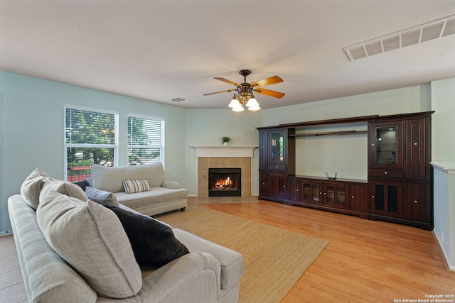 3738 Sumantra, San Antonio, TX 78261 - living area featuring light wood-style flooring, a tile fireplace, and ceiling fan