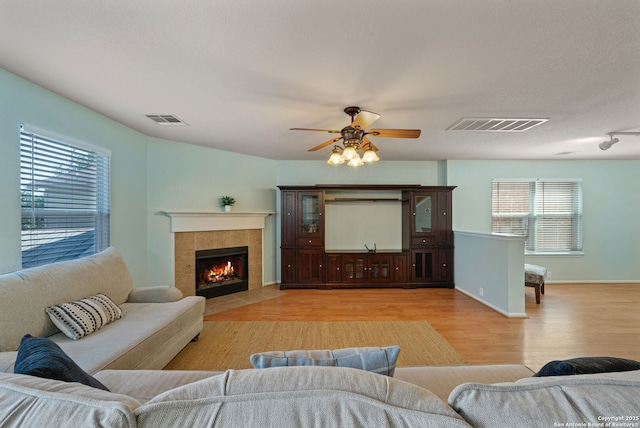 3738 Sumantra, San Antonio, TX 78261 - living area featuring light wood-type flooring, a ceiling fan, and a tiled fireplace