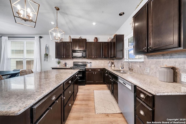 13410 Canyon Mdws, San Antonio, TX 78254 - kitchen with dishwasher, black microwave, a sink, a chandelier, and range with gas stovetop