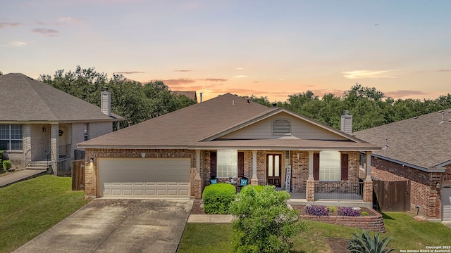 22841 San Saba Blf, San Antonio, TX 78258 - view of front of home with a garage, covered porch, brick siding, concrete driveway, and a lawn