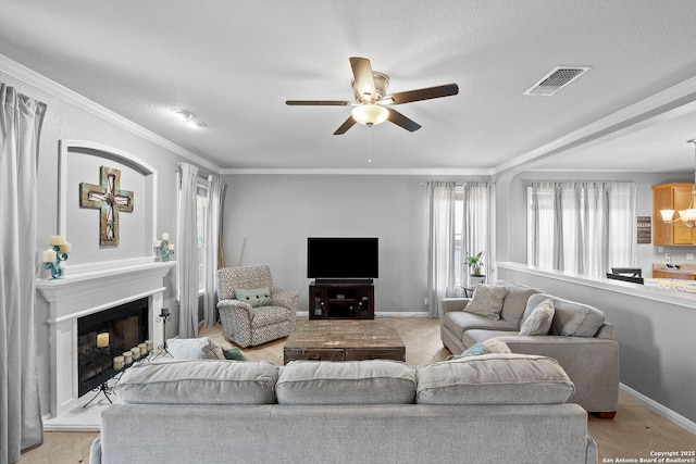 22841 San Saba Blf, San Antonio, TX 78258 - living room featuring healthy amount of natural light, ceiling fan, a fireplace with raised hearth, crown molding, and baseboards