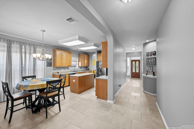 22841 San Saba Blf, San Antonio, TX 78258 - kitchen with stainless steel fridge with ice dispenser, a center island, light countertops, baseboards, and a chandelier