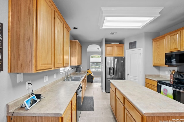 22841 San Saba Blf, San Antonio, TX 78258 - kitchen featuring black appliances, a sink, a kitchen island, arched walkways, and light countertops
