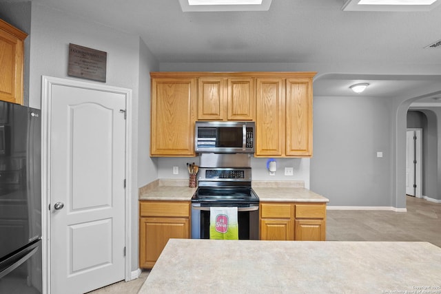 22841 San Saba Blf, San Antonio, TX 78258 - kitchen featuring stainless steel appliances, arched walkways, light countertops, and baseboards