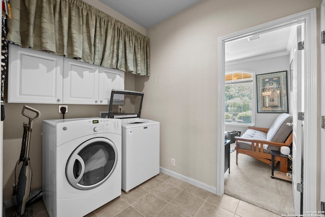 22841 San Saba Blf, San Antonio, TX 78258 - clothes washing area with separate washer and dryer, cabinet space, baseboards, crown molding, and light tile patterned flooring