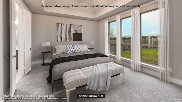 carpeted bedroom featuring baseboards and a raised ceiling
