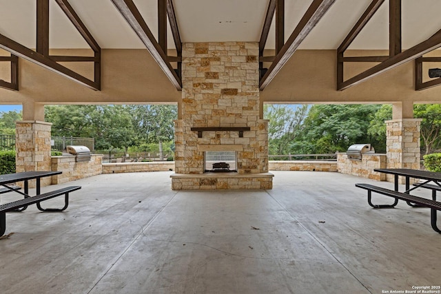 8515 Desert Cv, San Antonio, TX 78254 - view of patio / terrace with an outdoor stone fireplace and view of wooded area