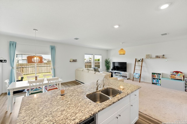 14407 Elkhorn Crst, San Antonio, TX 78253 - kitchen with a sink, white cabinetry, light stone counters, hanging light fixtures, and open floor plan