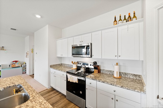 14407 Elkhorn Crst, San Antonio, TX 78253 - kitchen featuring stainless steel appliances, a sink, white cabinetry, light wood-type flooring, and recessed lighting