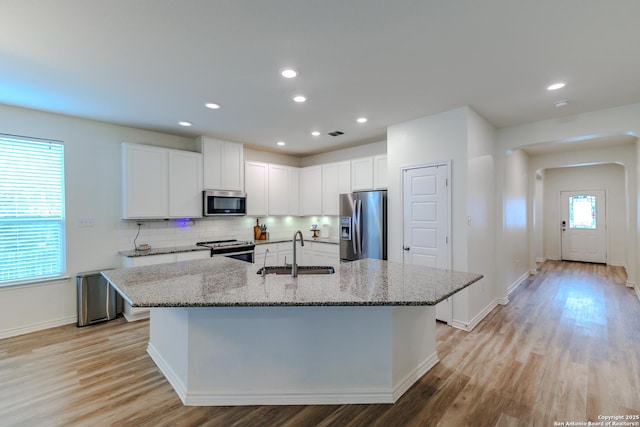 26323 Gibraltar, Boerne, TX 78015 - kitchen featuring a sink, appliances with stainless steel finishes, light stone countertops, white cabinets, and backsplash