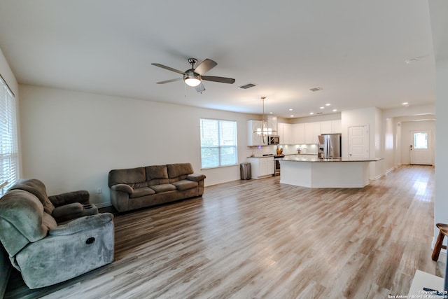 26323 Gibraltar, Boerne, TX 78015 - living area with healthy amount of natural light, light wood-style floors, a chandelier, a ceiling fan, and recessed lighting