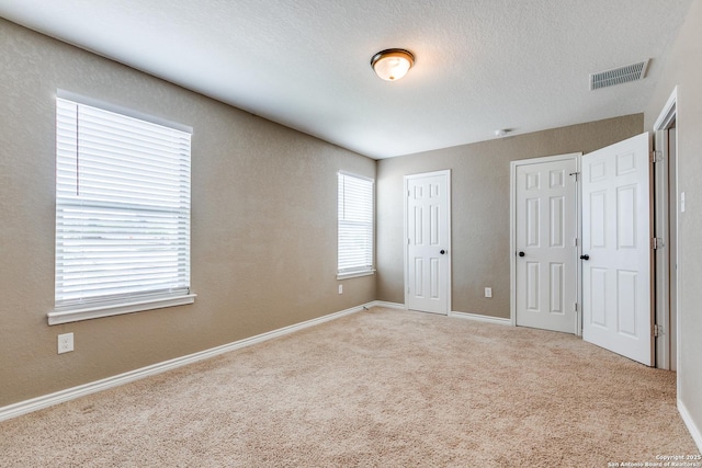 14802 Achilles Dr, San Antonio, TX 78245 - unfurnished bedroom featuring multiple closets, carpet, and baseboards