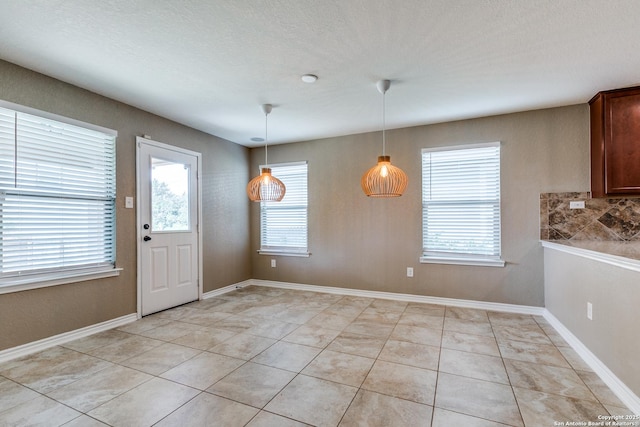 14802 Achilles Dr, San Antonio, TX 78245 - unfurnished dining area featuring light tile patterned flooring and baseboards