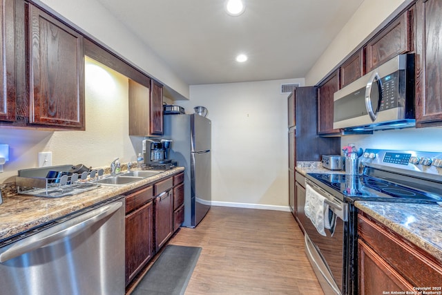 255 E Rampart Unit 401, San Antonio, TX 78216 - kitchen with stainless steel appliances, light wood finished floors, baseboards, a sink, and recessed lighting