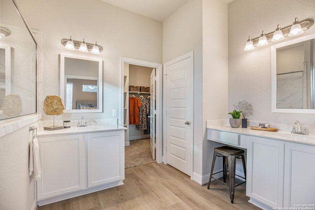 178 Jax Loop, San Antonio, TX 78253 - full bathroom with wood finished floors, two vanities, a shower, and a walk in closet