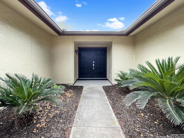 property entrance with stucco siding
