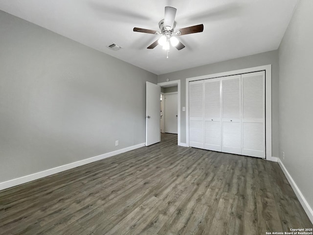 unfurnished bedroom featuring baseboards, a closet, wood finished floors, and ceiling fan