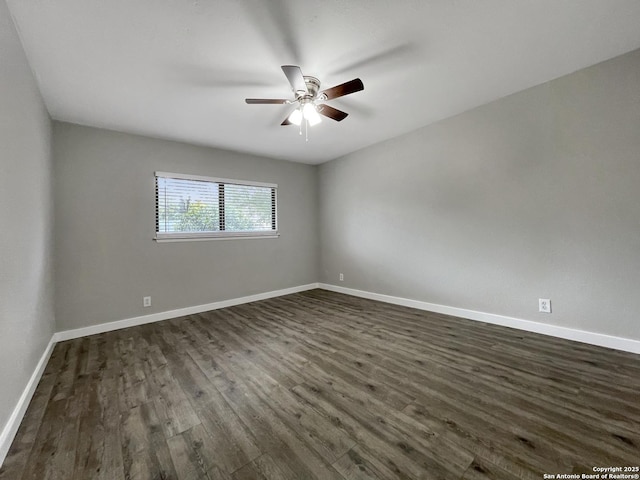 unfurnished room with dark wood-type flooring, ceiling fan, and baseboards