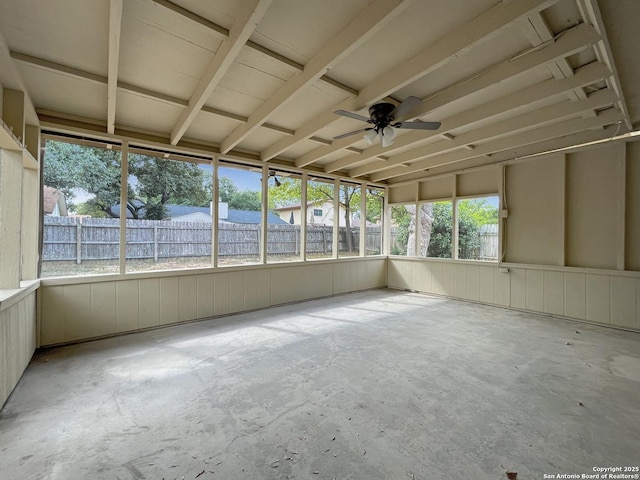 unfurnished sunroom with ceiling fan and concrete floors