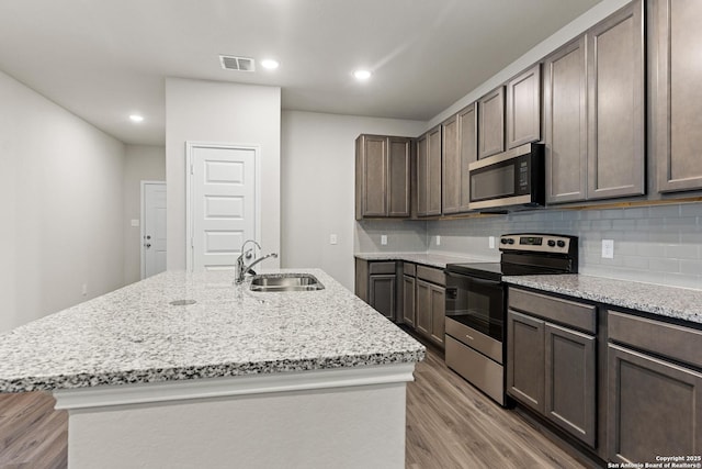 9318 Graze Br, San Antonio, TX 78211 - kitchen with stainless steel appliances, a sink, light wood-type flooring, decorative backsplash, and recessed lighting