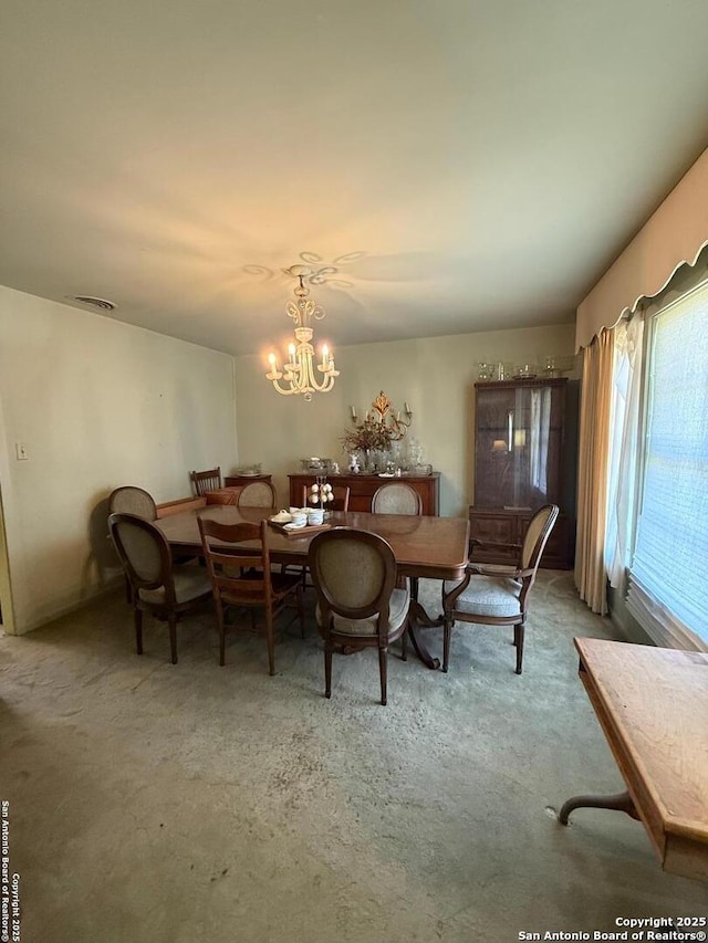carpeted dining space featuring a chandelier