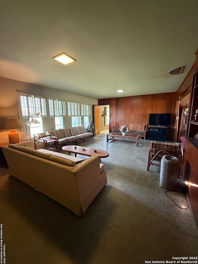 living area featuring healthy amount of natural light and wood walls