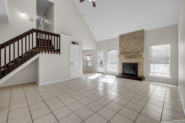 11819 Rousseau, San Antonio, TX 78251 - unfurnished living room with high vaulted ceiling, stairs, tile patterned flooring, a fireplace, and a ceiling fan