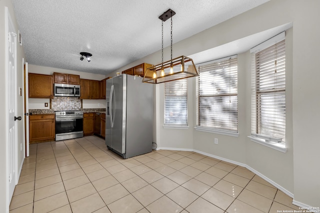 11819 Rousseau, San Antonio, TX 78251 - kitchen with appliances with stainless steel finishes, brown cabinets, healthy amount of natural light, a textured ceiling, and decorative backsplash