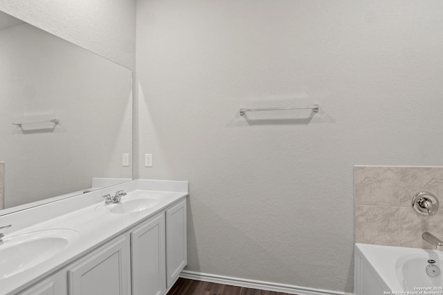 9410 Graze Land, San Antonio, TX 78211 - bathroom with wood finished floors, a bath, double vanity, and baseboards