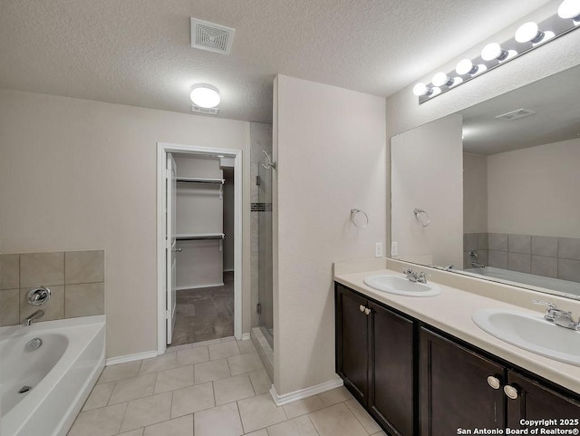 full bath featuring a garden tub, a shower stall, tile patterned floors, double vanity, and baseboards