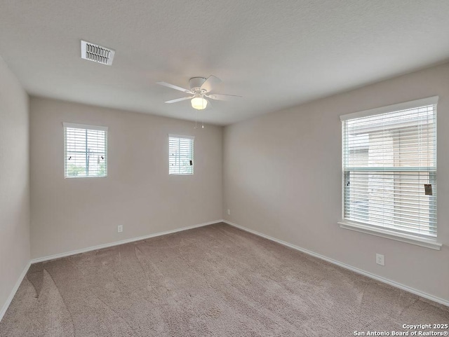 carpeted empty room with a ceiling fan and baseboards