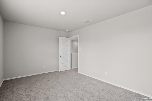 carpeted empty room featuring baseboards
