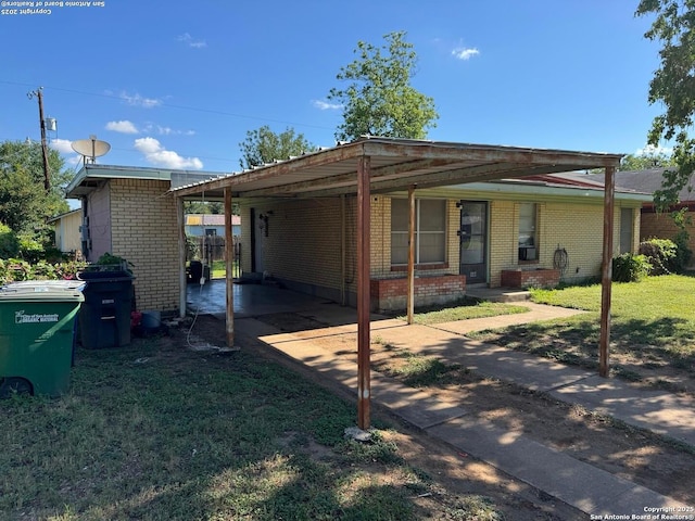 227 E Villaret Blvd, San Antonio, TX 78221 - view of front of property featuring brick siding, a front yard, concrete driveway, and an attached carport