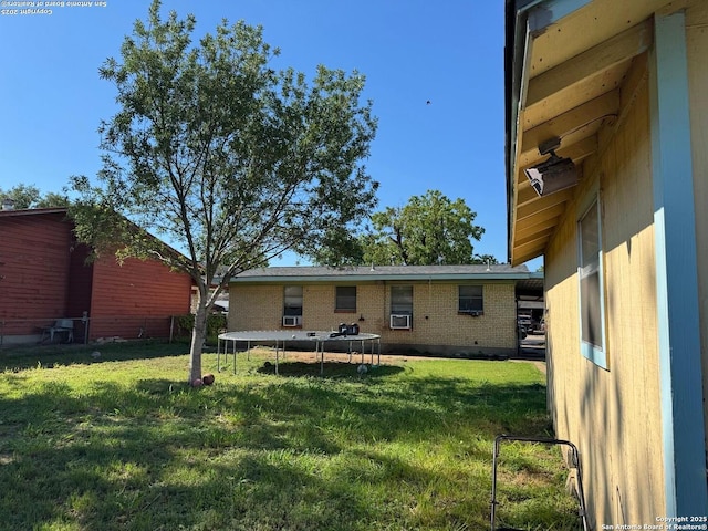 227 E Villaret Blvd, San Antonio, TX 78221 - rear view of property with a trampoline, brick siding, and a yard