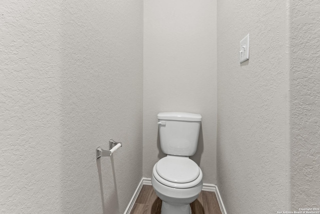 9322 Graze Br, San Antonio, TX 78211 - bathroom with wood finished floors, baseboards, a textured wall, and toilet