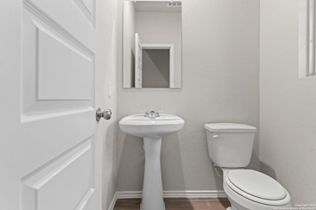 9322 Graze Br, San Antonio, TX 78211 - bathroom with toilet, wood finished floors, baseboards, and a sink