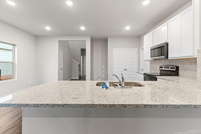 9322 Graze Br, San Antonio, TX 78211 - kitchen featuring stainless steel appliances, a sink, recessed lighting, white cabinets, and light stone countertops