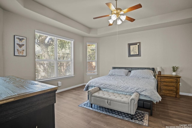 11734 Violet Cv, San Antonio, TX 78253 - bedroom with a tray ceiling, baseboards, wood finished floors, and ceiling fan
