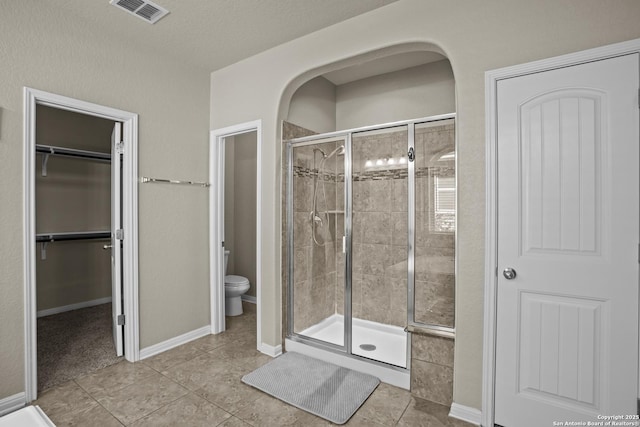 11734 Violet Cv, San Antonio, TX 78253 - bathroom with a shower stall, toilet, tile patterned floors, and a walk in closet