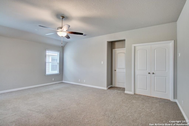 unfurnished bedroom featuring carpet floors, baseboards, a ceiling fan, a closet, and a textured ceiling
